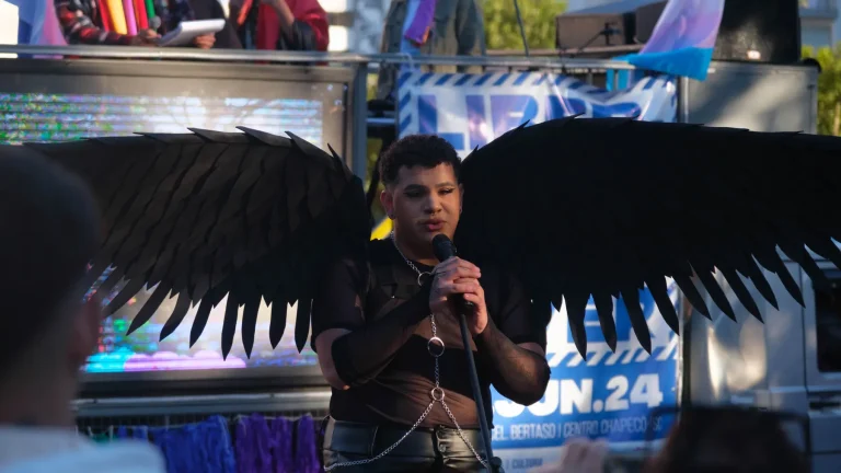 A performer with black wings on the mic atop the float.