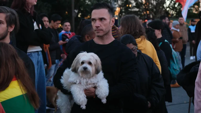 A participant carries their dog in the crowd.