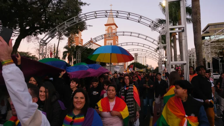 Rainbow umbrellas under the lit arches at dusk.