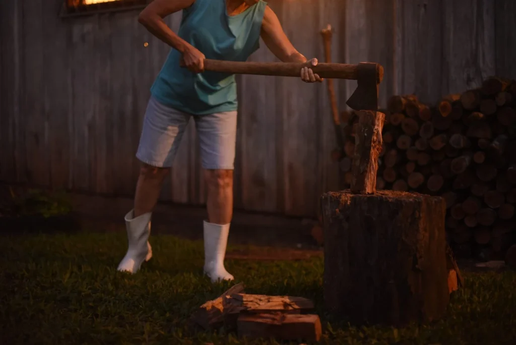 O que é de César: personagem racha lenha de botas brancas diante do galpão