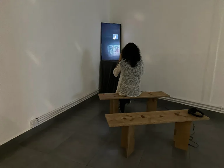 Visitante sentada no banco diante do monitor vertical com do peito da pele