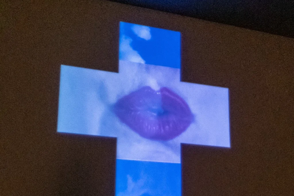 A cruz de do peito da pele projetada no 11º Salão Nacional Victor Meirelles, no MASC: uma boca sobre o céu azul