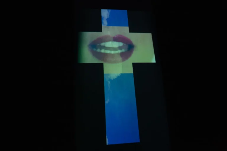 Cruz projetada com uma boca de batom vermelho, na estreia no Sesi/PR