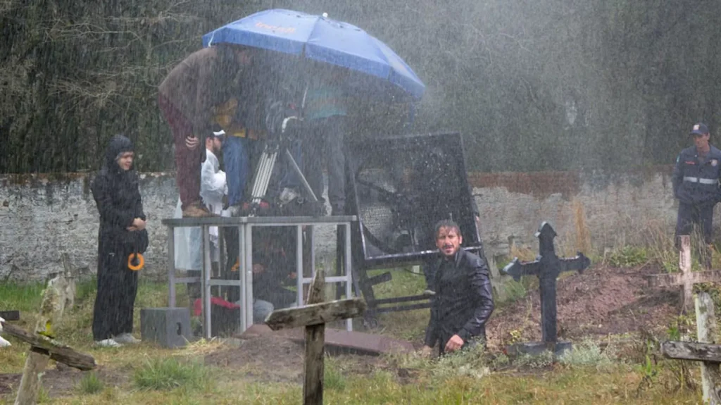 Set de filmagem de Preto Pálido: equipe e câmera num cemitério sob chuva